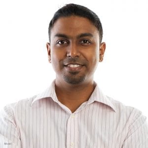 Headshot of a smiling adult male with a defined nose and wearing a button up shirt