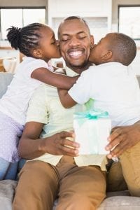 Man getting kisses from his kids