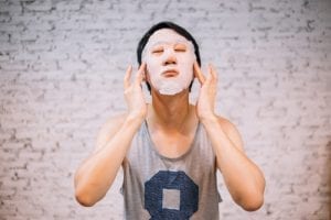 young handsome asian man having skincare facial mask on his face at home - cosmetology-img-blog